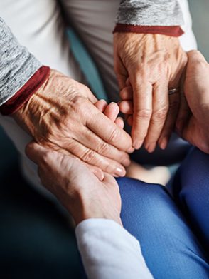 Cropped shot of a nurse holding a senior woman’s hands in a retirement home